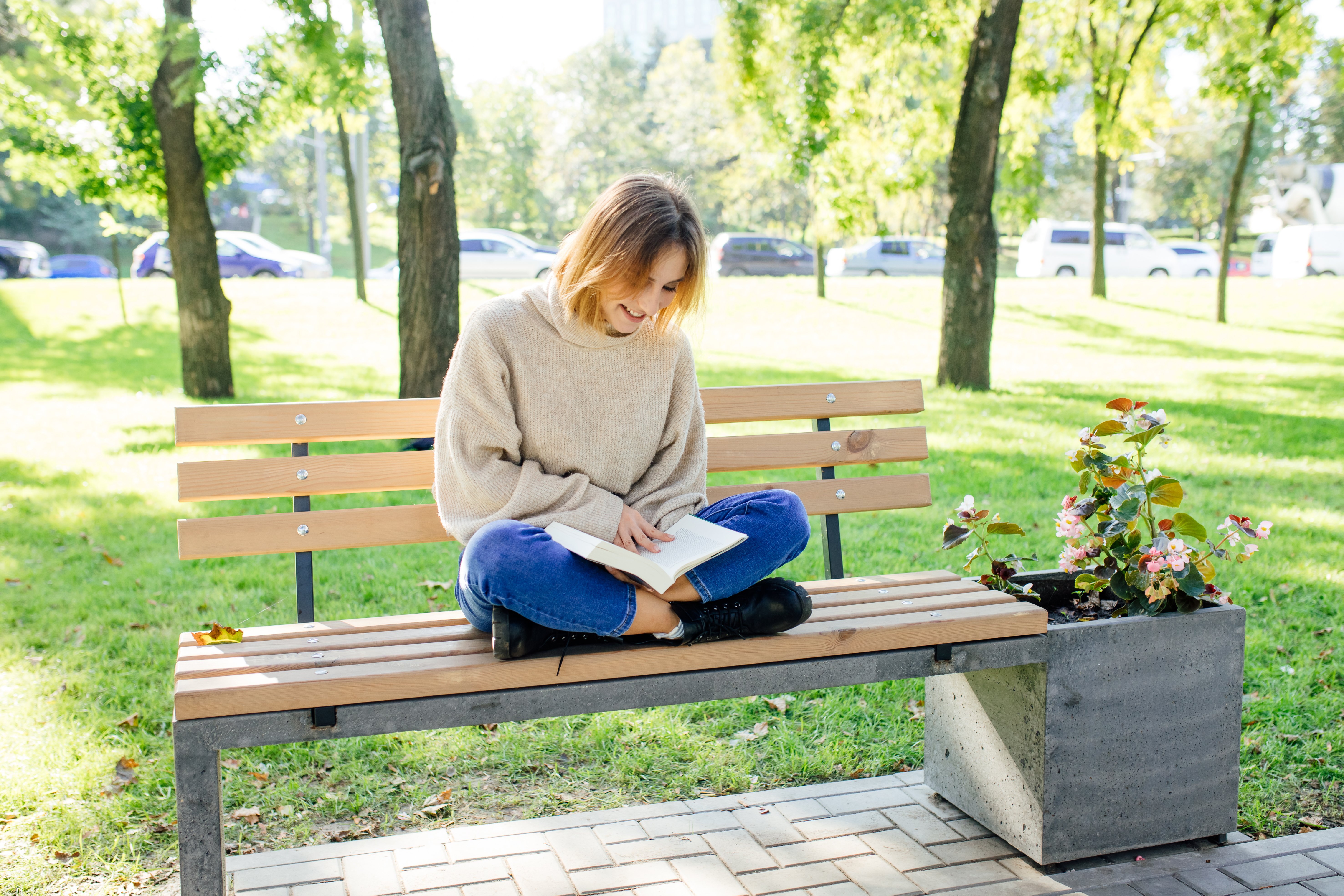 young-girl-reading-book-outside-sitting-on-a-bench-2022-04-19-22-54-23-utc